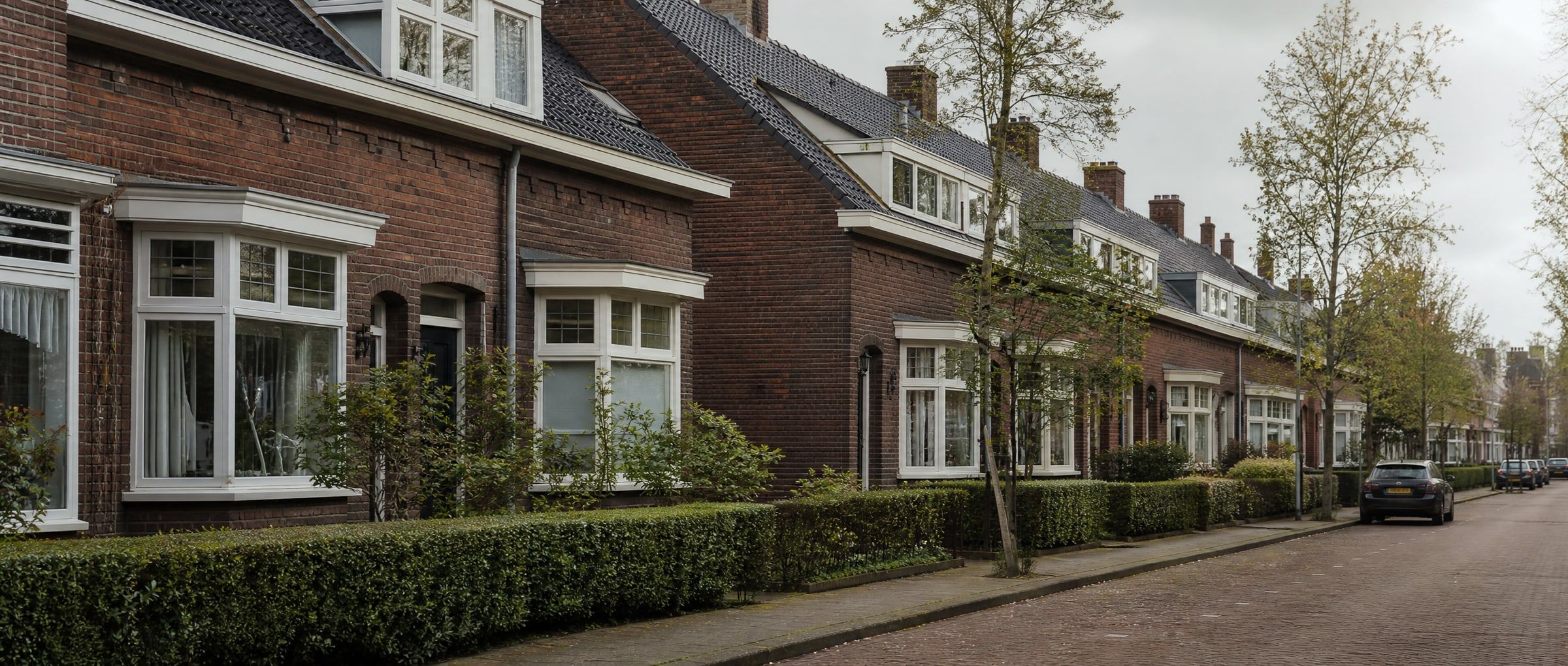 Straat met Nederlandse jaren-30 woningen met erkers en pannendaken