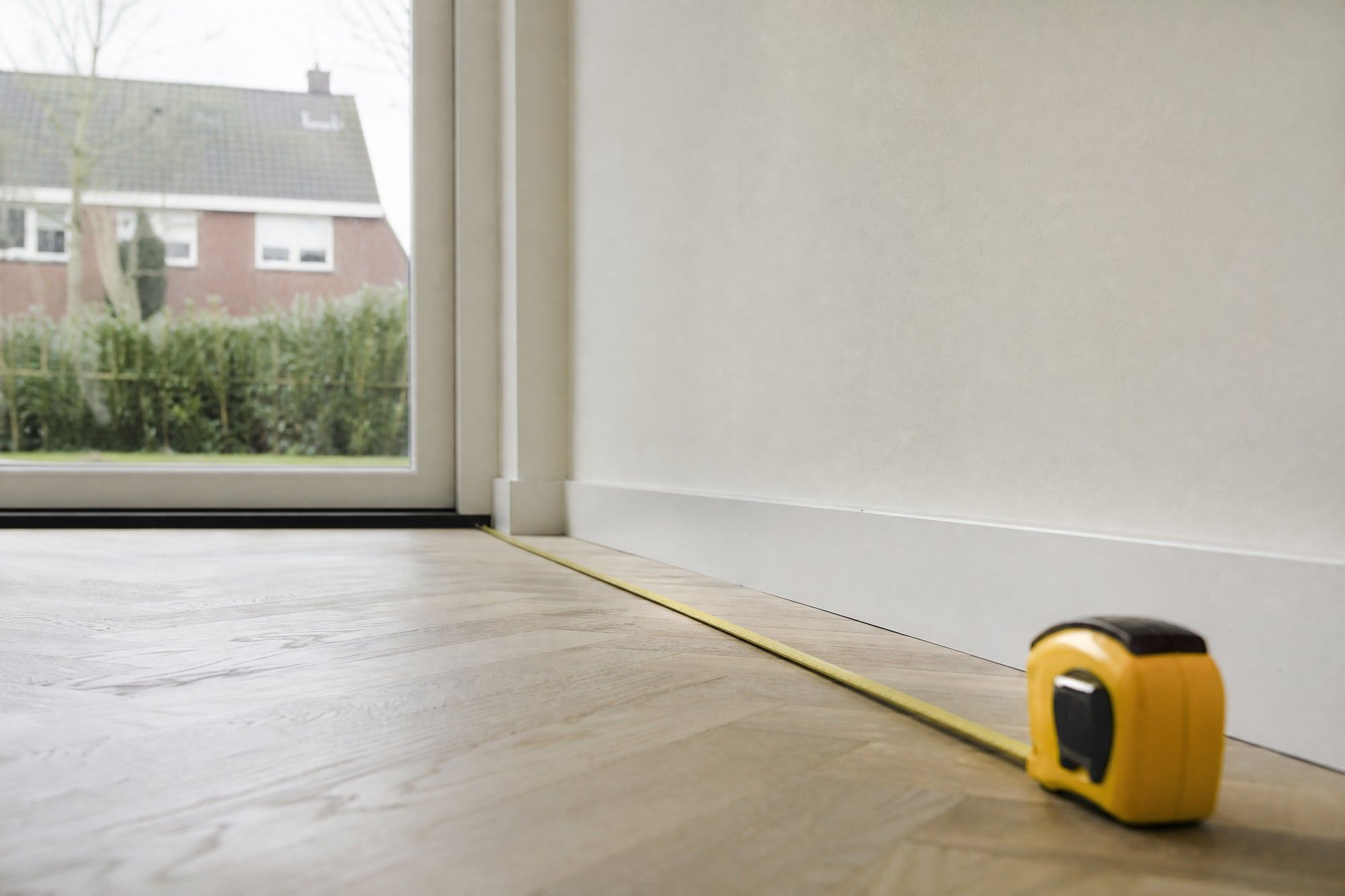 Rolmaat uitgetrokken over een houten vloer