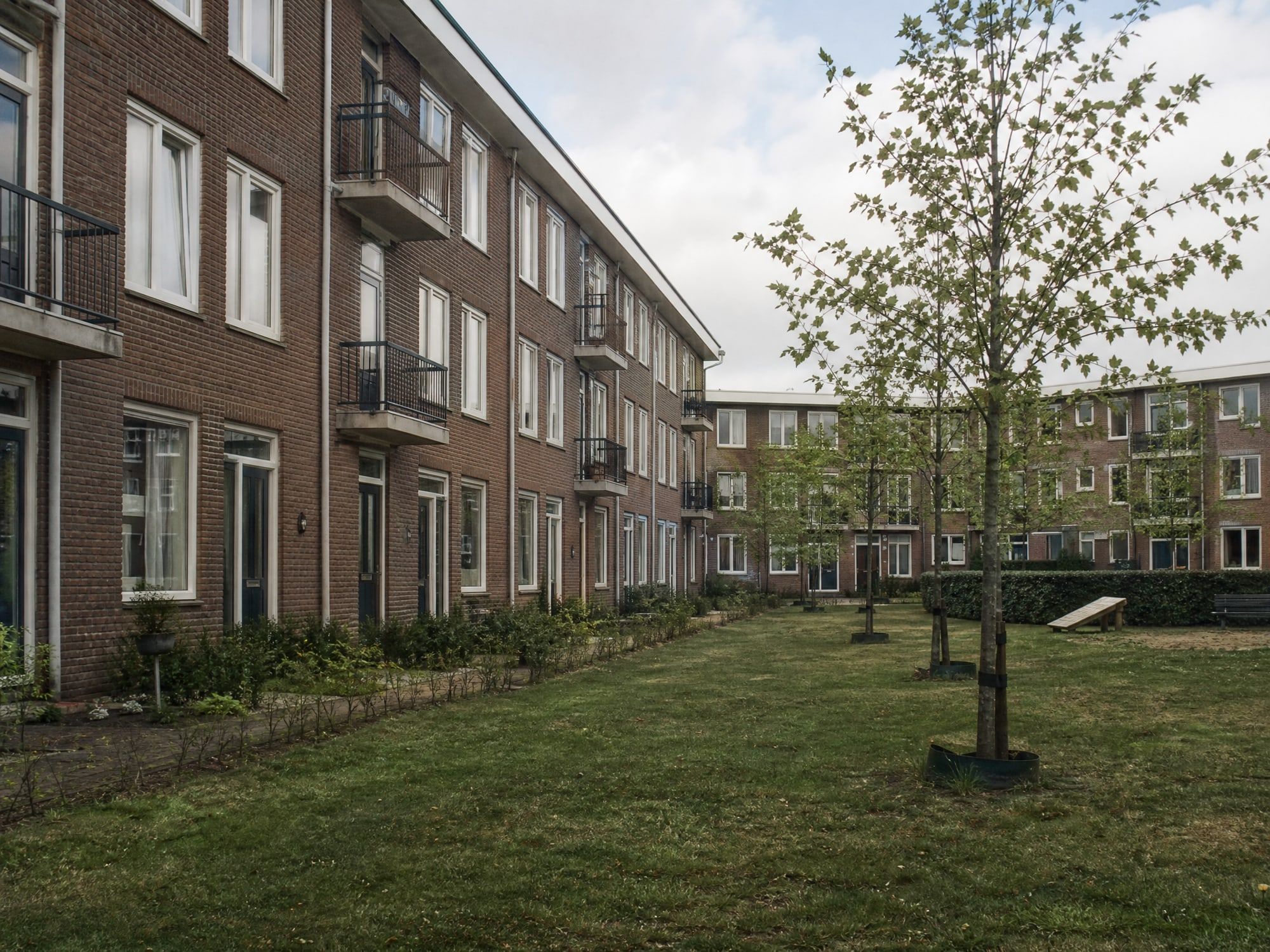 Bakstenen appartementencomplex rond een groene binnentuin